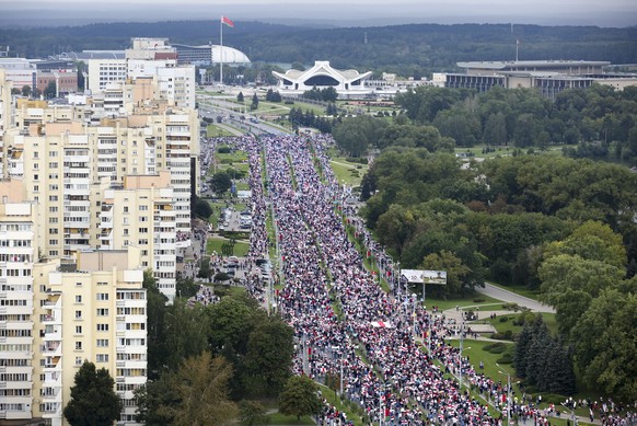 Belarusian opposition supporters with old Belarusian national flags gather toward the Independence Palace, the residential of Belarusian President Alexander Lukashenko in Minsk, Belarus, Sunday, Sept. ...