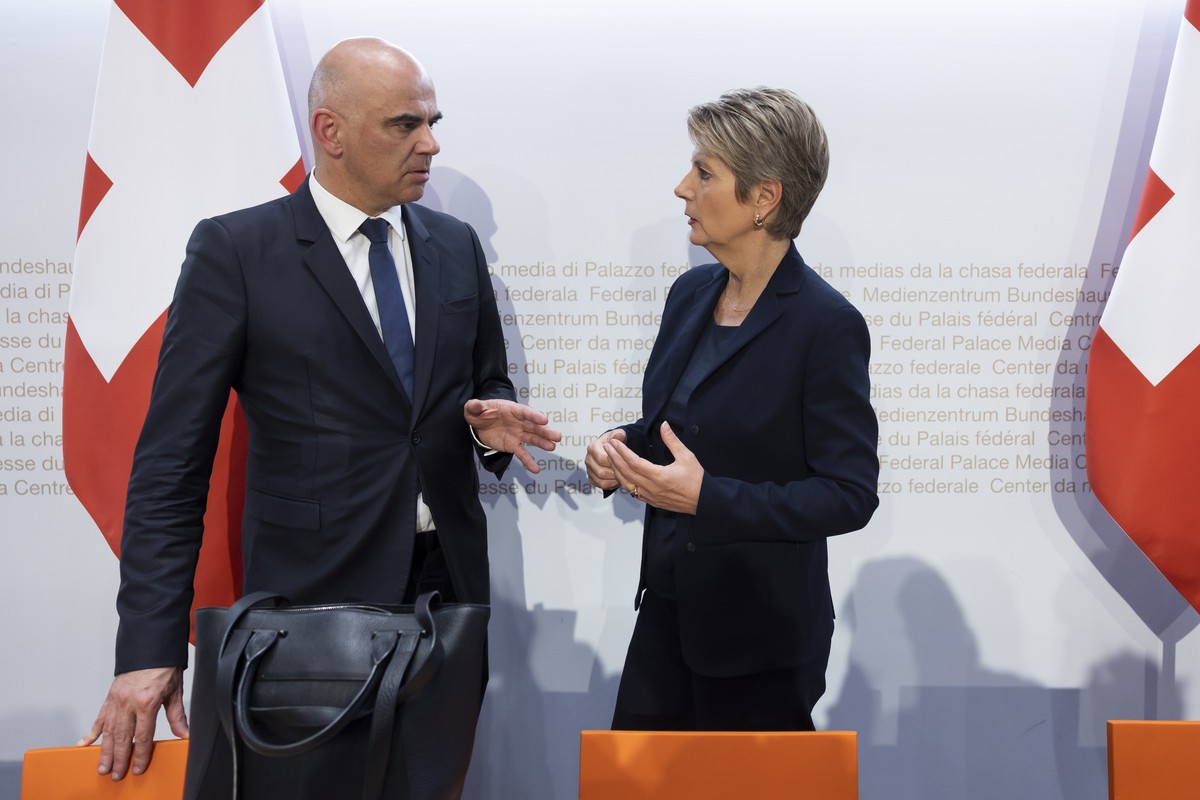 epa10532835 Swiss Federal President Alain Berset (L) and Swiss Finance Minister Karin Keller-Sutter (R) talk at the end of a press conference in Bern, Switzerland, 19 March 2023. The Swiss government  ...