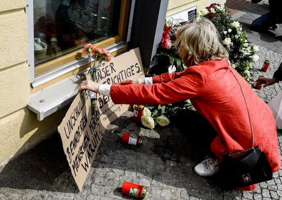epa09167457 Gerlinde Helbing, wife of Director of the Association of Deaf people in Berlin and Brandenburg, places signs read &#039;Why murder innocent disabled people?&#039; and &#039;Our sincere con ...