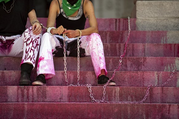 epa10055997 Abortion rights demonstrators chain themselves to the pillars in front of the entrance of the City Hall to protest following the decision by the US Supreme Court to overturn the Roe v. Wad ...