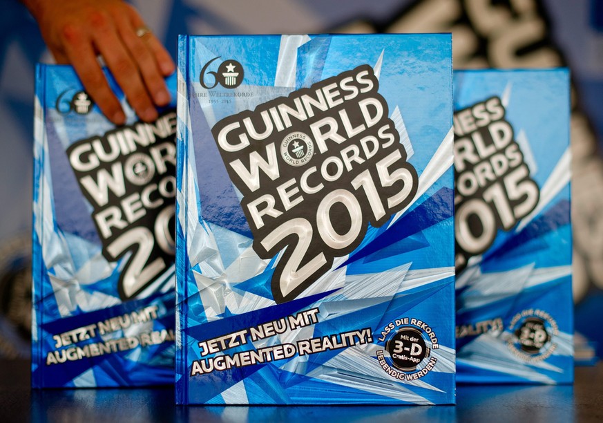 epa04393777 The anniversary issue of the Guinness Book of World Records 2015 sits on a table during a press event in Hamburg, Germany, 10 September 2014. The new Guiness Book of World Records is on sa ...