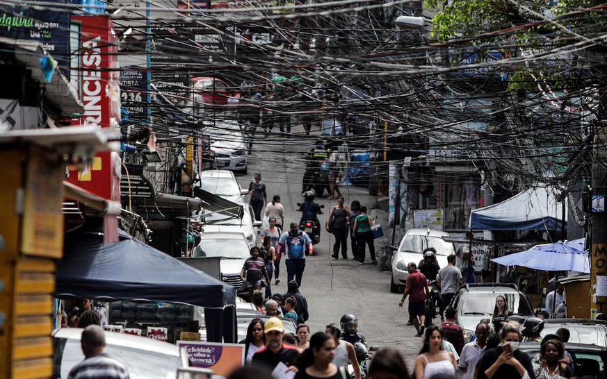 epa08353979 People walk in the Rocinha favela in Rio de Janeiro, Brazil, 09 April 2020. The elderly who live in the favelas of the Brazilian city of Rio de Janeiro, one of the groups most at risk in t ...
