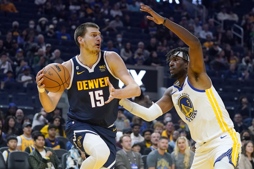 Denver Nuggets center Nikola Jokic (15) looks to pass the ball against Golden State Warriors center Kevon Looney (5) during the first half of an NBA preseason basketball game in San Francisco, Friday, ...