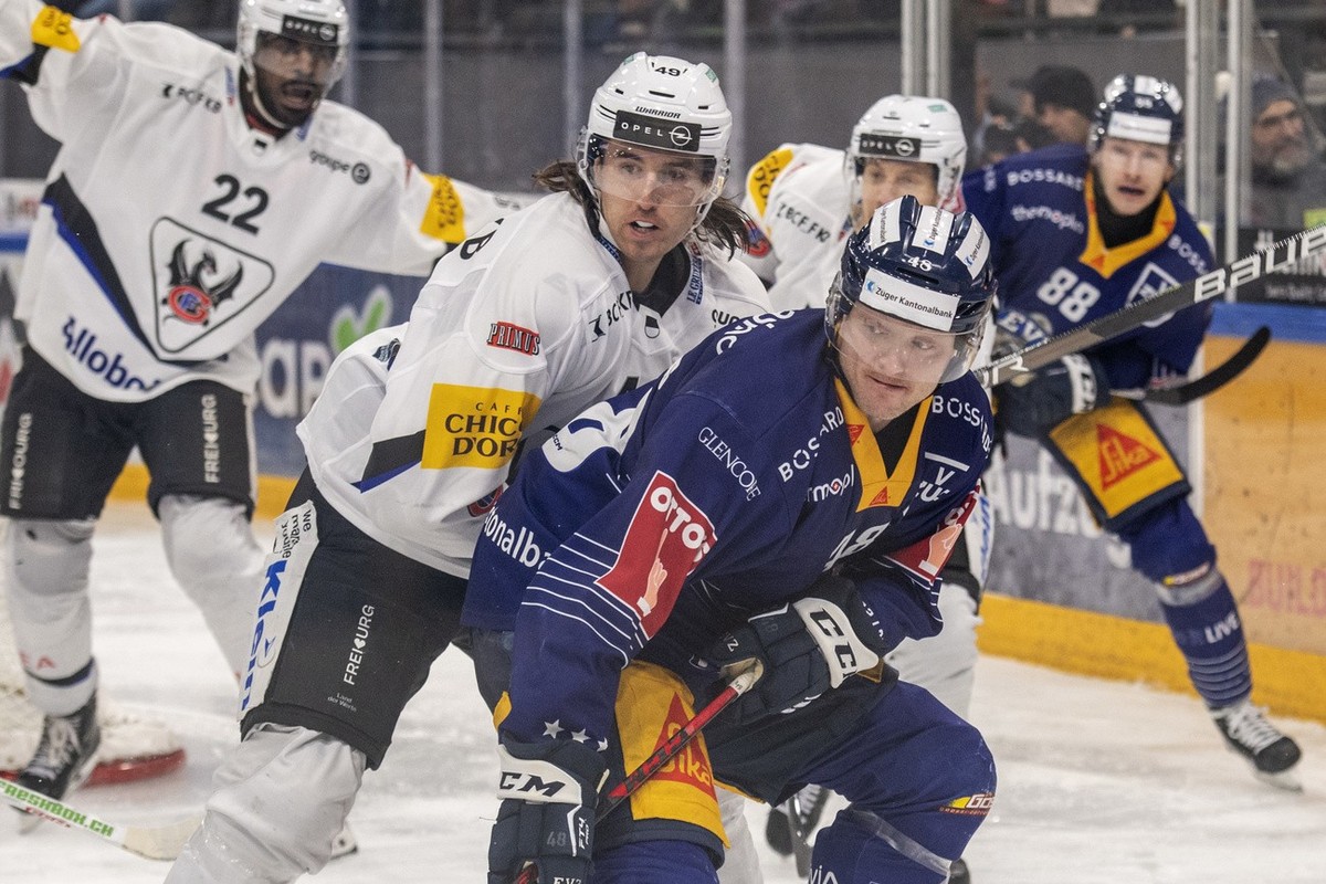 Carl Klingberg, mitte rechts, von Zug im Spiel gegen Victor Rask, mitte links, von Fribourg beim Eishockey Meisterschaftsspiel der National League zwischen dem EV Zug und dem Fribourg Gotteron am Dien ...