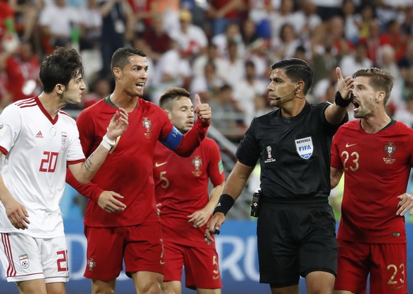 Iran&#039;s Sardar Azmoun, left, Portugal&#039;s Cristiano Ronaldo argue with referee Enrique Caceres during the group B match between Iran and Portugal at the 2018 soccer World Cup at the Mordovia Ar ...