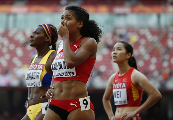 Mujinga Kambundji of Switzerland (C), Narcisa Landazuri of Ecuador (L) and Wei Yongli of China look at the scoreboard after their women&#039;s 100 metres heat at the 15th IAAF World Championships at t ...