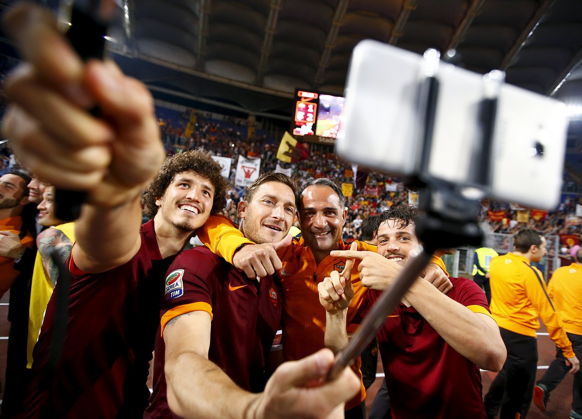 AS Roma's Francesco Totti (2nd L) takes a selfie with his team mates Alessandro Florenzi (R) and Salih Ucan (L) at the end of their Italian Serie A soccer match against Palermo at the Olympic sta ...