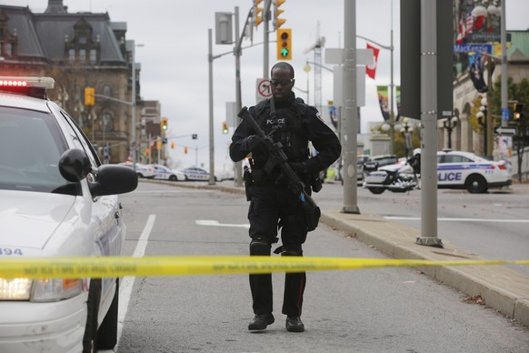 Ein Polizist einer Spezialeinheit sichert am Mittwoch eine Strassenkreuzung in Ottawa – die kanadische Hauptstadt steht einen Tag nach den Angriffen immer noch unter Schock.