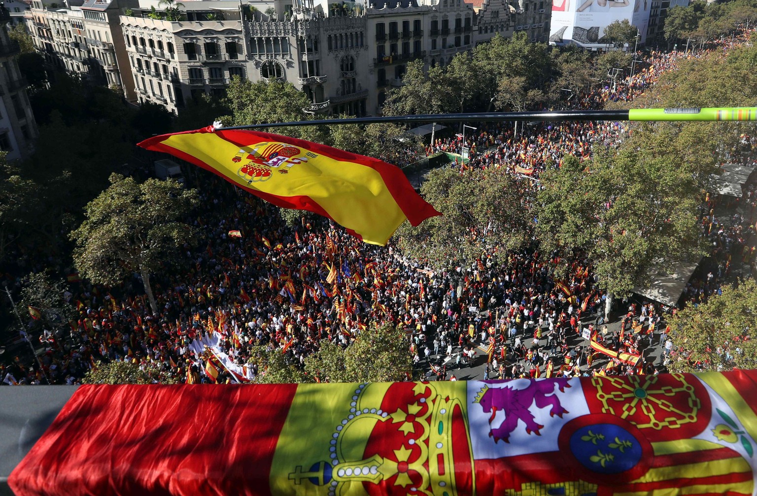 epa06296464 A Spansih flag waves as thousands of Catalan pro-union people march along the Paseo de Gracia avenue in Barcelona during a protest called by the Societat Civil Catalana (lit: Catalan Civil ...
