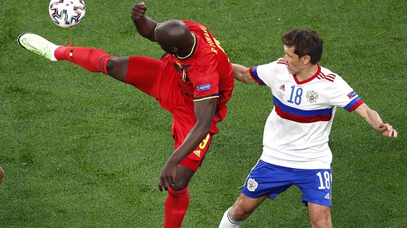 epa09265859 Romelu Lukaku (C) of Belgium in action against Russian players Magomed Ozdoyev (L) and Yuri Zhirkov (R) during the UEFA EURO 2020 group B preliminary round soccer match between Belgium and ...