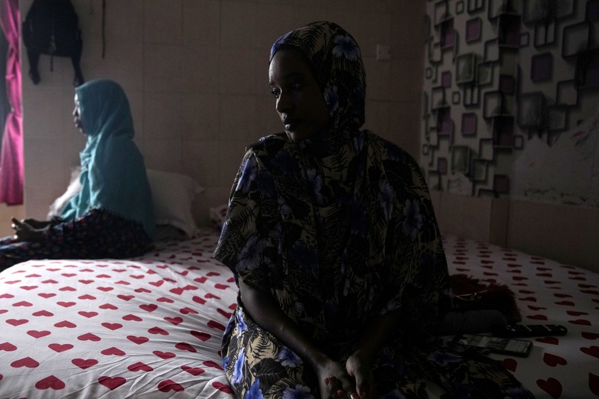 Nagad Daoud Abdallah, right, and Majdah Ishag, both from Sudan, sit on a bed in Ishag&#039;s room at a hotel turned into a shelter for refugees in Batam, an island in northwestern Indonesia, Thursday, ...