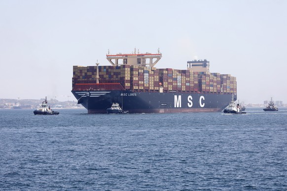 epa10674510 The world's largest container ship, MSC Loreto, is helped by tugboats to dock at the APM container terminal in the port of Algeciras (Cadiz), Spain, June 5, 2023. The new MSC Loret ...