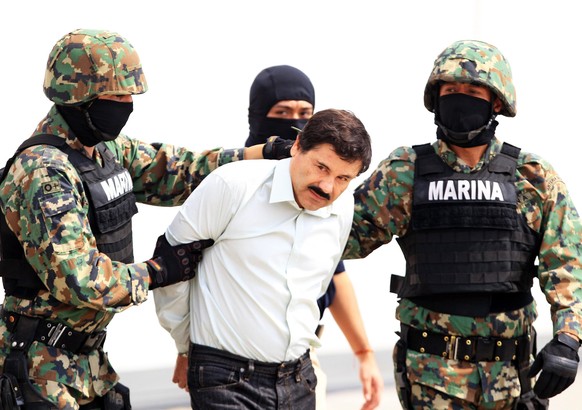 epa04843408 (FILE) A file photograph showing members of the Mexican military holding Mexican drug lord Joaquin Guzman Loera, alias &#039;El Chapo&#039; (C) at the Navy hangar in Mexico City, Mexico, 2 ...