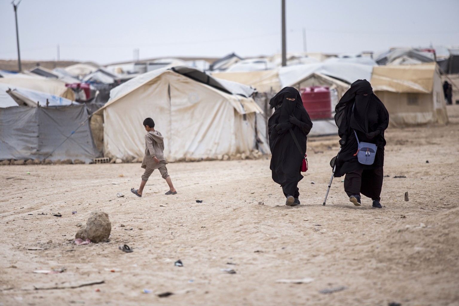 FILE - Women walk in the al-Hol camp that houses some 60,000 refugees, including families and supporters of the Islamic State group, many of them foreign nationals, in Hasakeh province, Syria, on May  ...