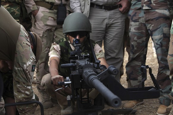 Ein Kämpfer der kurdischen Peshmerga-Streitkräfte wird wird von britischen Soldaten im Gebrauch eines Maschinengewehrs unterrichtet. Britische Spezialisten unterstützen die Streitkräfte der autonomen  ...