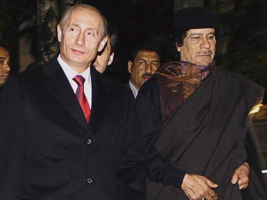 epa01538492 Russian Prime Minister Vladimir Putin (L), Libyan leader Muammar Gaddafi (C) and French singer Mireille Mathieu (R) on their way to Gaddafi&#039;s bedouin tent in Taininsky park in the Kre ...