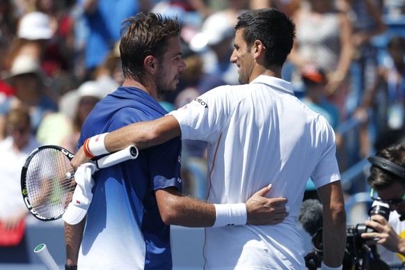 Novak Djokovic, of Serbia, right, hugs Stanislas Wawrinka, of Switzerland, after their quarterfinal match at the Western &amp; Southern Open tennis tournament, Friday, Aug. 21, 2015, in Mason, Ohio. D ...