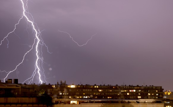 epa10760953 Lightning illuminates the sky over a residential building in Belgrade, Serbia, 21 July 2023. A supercell storm has hit northern parts of Serbia causing material damage. EPA/ANDREJ CUKIC