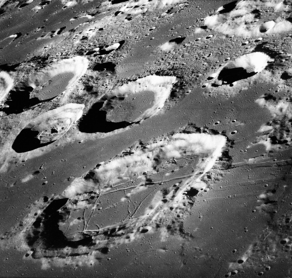 FILE - This Dec. 29, 1968 photo made available by NASA shows the large moon crater Goclenius, foreground, approximately 40 statute miles in diameter, and three clustered craters Magelhaens, Magelhaens ...