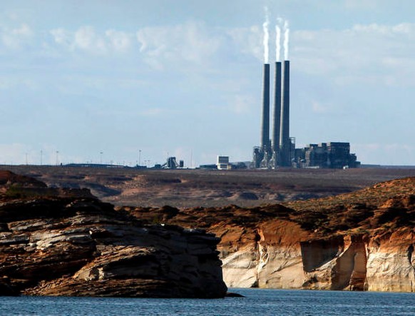 FILE - In this Sept. 4, 2011, file photo, smoke rises from the stacks of the main plant facility at the Navajo Generating Station, as seen from Lake Powell in Page, Ariz. The owners of one of the larg ...