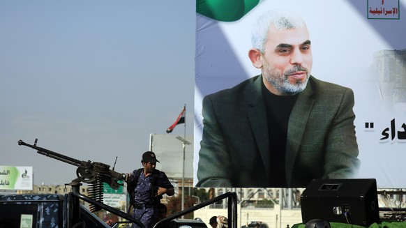 epa12460690 A Houthi soldier (L) mans a machine gun on a pick-up truck near a banner depicting late Hamas leader Yahya Sinwar, during a protest rally against Israel, in Sana'a, Yemen, 17 October  ...