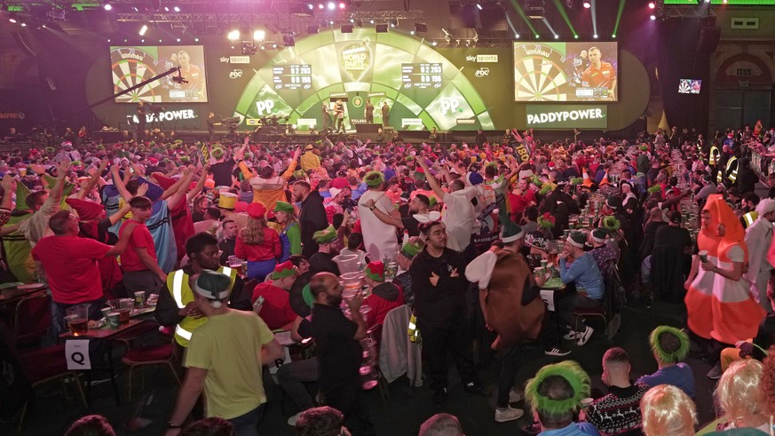 Darts fans celebrate on day eight of the World Darts Championship, at Alexandra palace in London, Friday, Dec. 22, 2023. (AP Photo/Kin Cheung)