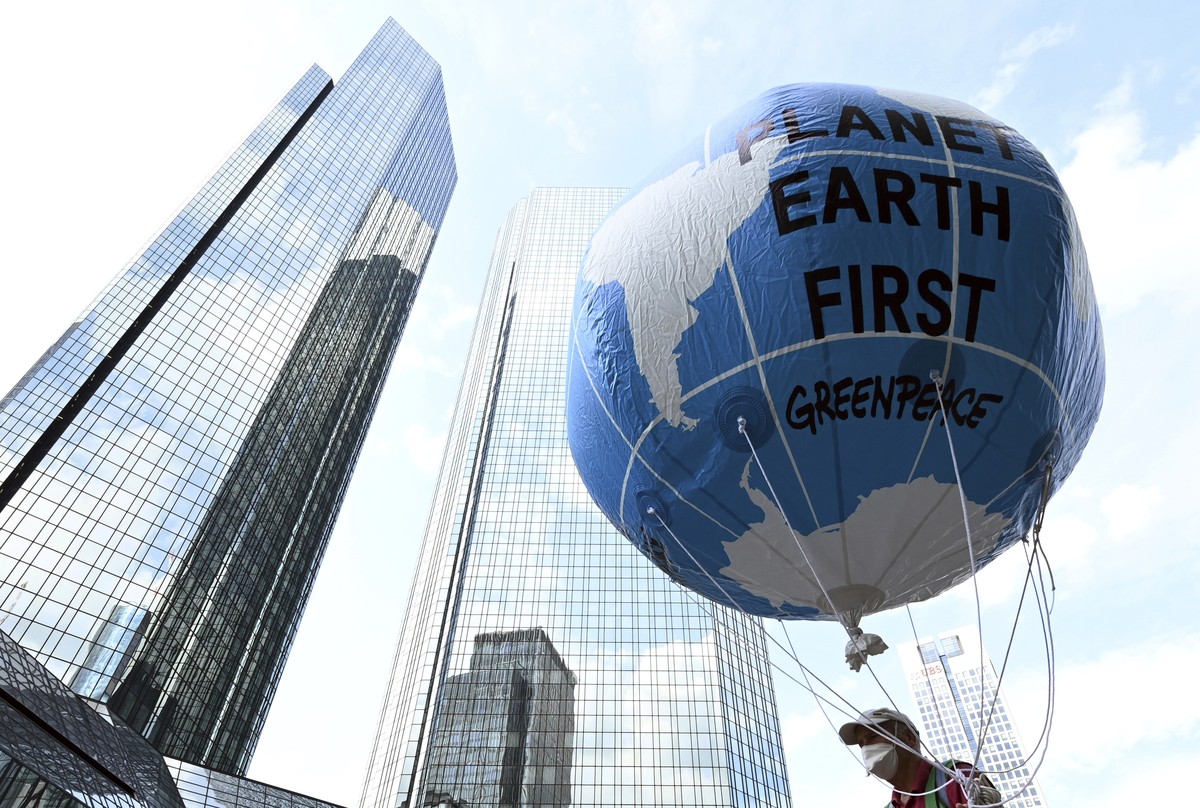 A demonstrator holds a balloon with the words "Planet Earth First" at the Fridays for Future central climate strike in Frankfurt, Germany, Friday Aug. 13, 2021, with Deutsche Bank headquarte ...