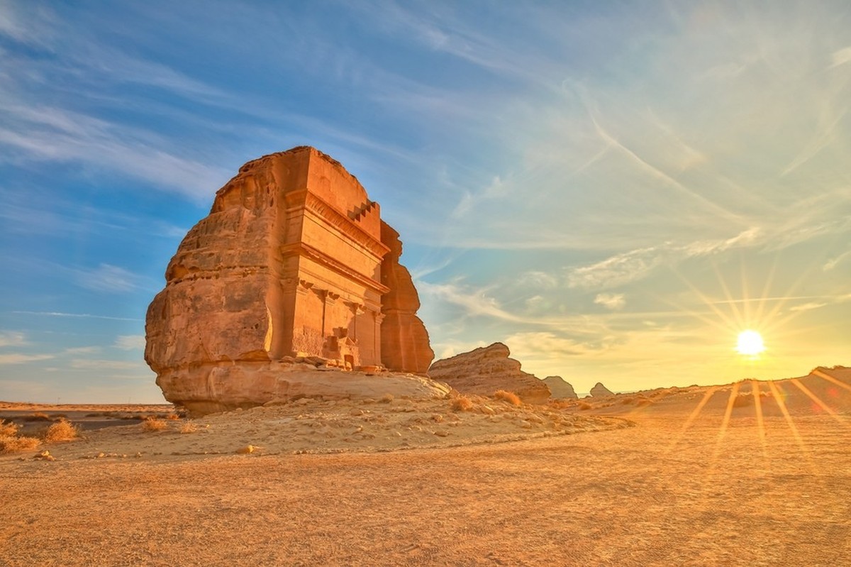 Das majestätische Qasr Al Farid, auch bekannt als das Grab des lihischen Sohnes Kuzas, steht hoch in der Hegra Wüste von Al Ula, Saudi Arabien, eingebettet in den warmen Glanz der untergehenden Sonne