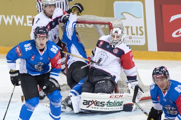 Zug's Sven Senteler, left, and Berlin's goalkeeper Marvin Cuepper, right, during the ice hockey Champions League match 1/16 Final between EHC Zug and Eisbaeren Berlin, in Zug, Switzerland, T ...