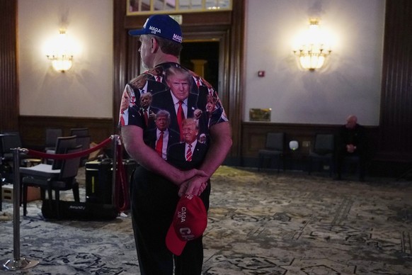 A supporter of former President Donald Trump walks through the ballroom at the Republican guard party in Scottsdale, Arizona, Wednesday, Nov. 9, 2022. (AP Photo/Ross D. Franklin)