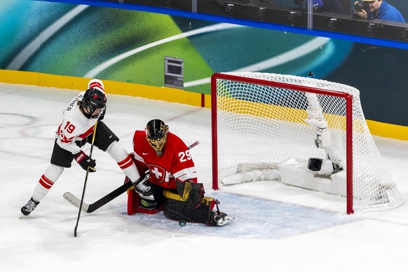 Switzerland's goaltender Saskia Maurer #29 saves a puck past Canada's Brianne Jenner #19, during the women's group A preliminary round game between Switzerland and Canada at the 2026 Ol ...