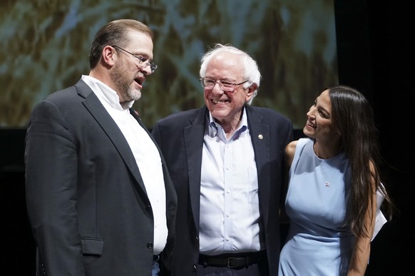 Kansas congressional candidate James Thompson, left, U.S Sen. Bernie Sanders, I-Vt., and Alexandria Ocasio-Cortez, a Democratic congressional candidate from New York, stand together on stage after a r ...