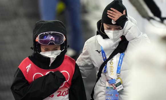 epa09735597 Sara Takanashi of Japan (L) with a teammember reacts after being disqualified during the Mixed Team Ski Jumping Normal Hill first round at the Zhangjiakou National Ski Jumping Centre at th ...