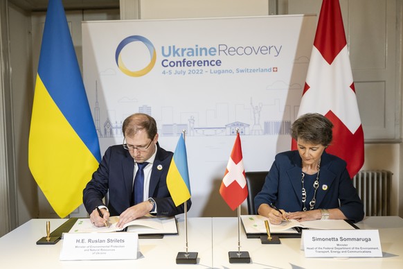 Swiss Federal Councillor Simonetta Sommaruga, Minister of Infrastructure, Transport, Environment and Energy, right, and Ukranian Minister of Ecology and Natural Resources Ruslan Strilets sign an Imple ...