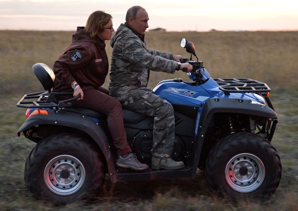 Russian President Vladimir Putin rides a quad bike as he visits a reserve for wild horses near the Urals city of Orenburg, about 1300 kilometers (800 miles) southeast of Moscow, Russia, Monday, Oct. 3 ...