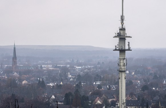 A mobile communications radio mast is seen over the town of Bottrop, Germany, Tuesday, March 7, 2023. German mobile network operators must reassess previously installed Chinese-made components…