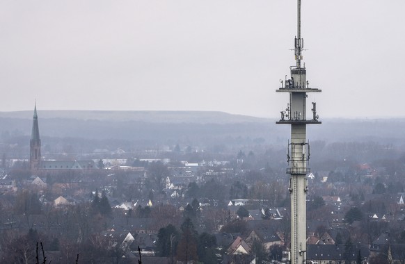 A radio mast for mobile communications is seen over the town of Bottrop, Germany, Tuesday, March 7, 2023. German mobile network operators have to reassess previously installed Chinese-made components  ...