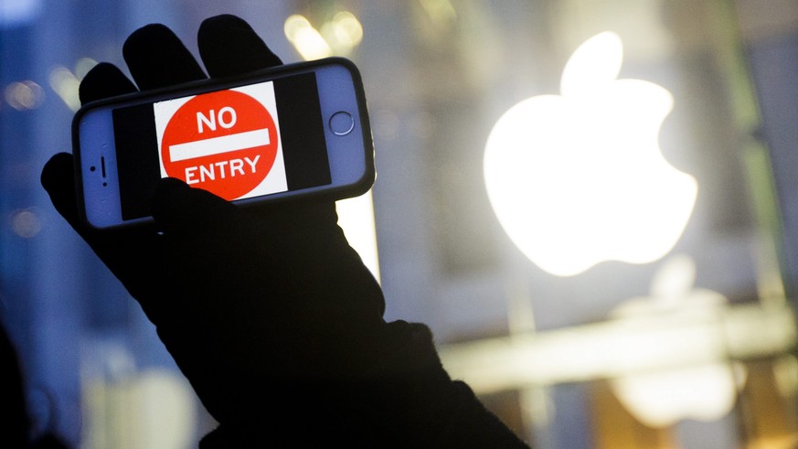 epa05234175 (FILE) A file picture dated 23 February 2016 shows a man holding up an iPhone displaying a &#039;No Entry&#039; image as part of a rally in front of an Apple Store in support of the compan ...