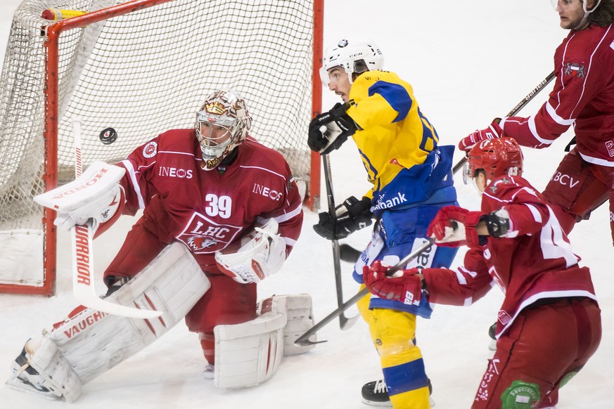 Le gardien lausannois Cristobal Huet, gauche, lutte pour le puck avec l&#039;attaquant davosiens Marc Wieser, droite, lors du match du championnat suisse de hockey sur glace de National League A, entr ...