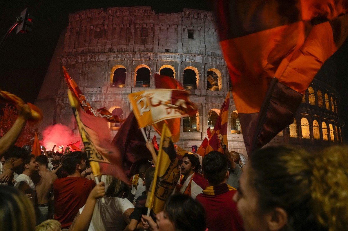 Supporters of AS Roma celebrate in front of the Colosseum in Rome their team's victory of the Europa Conference League final soccer match between Roma and Feyenoord played in Tirana, Wednesday, M ...