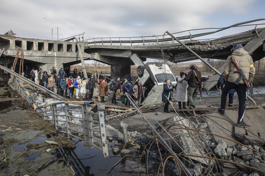 epa09812969 Residents cross the destroyed bridge as they flee from the frontline town of Irpin, Kyiv (Kiev) region, Ukraine, 09 March 2022. Irpin, the town which is located near Kyiv city had heavy fi ...