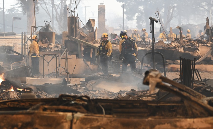 Firefighters work inside a burned structure while battling the Eaton Fire, Wednesday, Jan. 8, 2025, in Altadena, Calif. (AP Photo/Nic Coury)