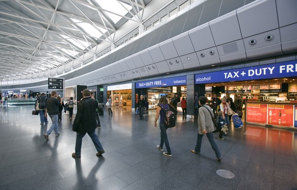 Travelers pass duty-free stores on their way through the &quot;Airside Center&quot;, which at once connects docks A and B, serves as a passenger hub and as Zurich Airport&#039;s landmark in Kloten in  ...