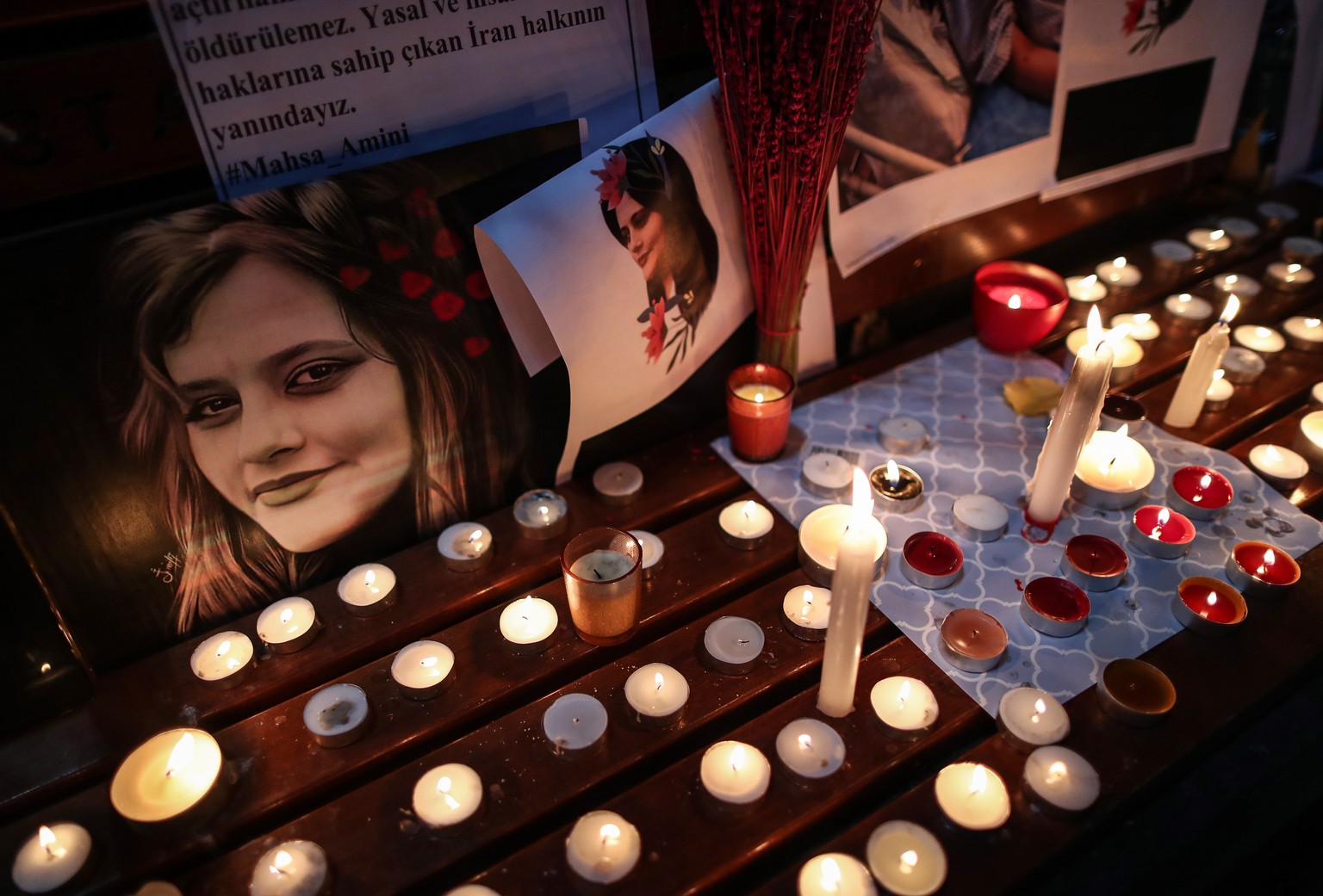 epa10195629 Iranian poeple light candles and hold pictures of Iranian Mahsa Amini druing a protest after her death, in Istanbul, Turkey, 20 September 2022. Mahsa Amini, a 22-year-old Iranian woman, wa ...