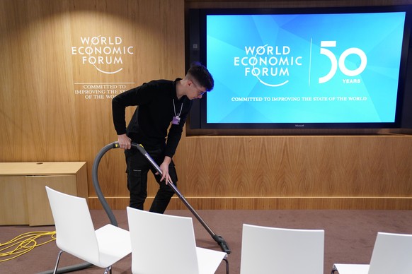 Staff member Rodrigo Rodrigues Amaral vacuums the floor prior to the 50th annual meeting of the World Economic Forum, WEF, in Davos, Switzerland, Monday, January 20, 2020. The meeting brings together entrepreneurs, scientists, corporate and political leaders in Davos from January 21 to 24. (KEYSTONE/Alessandro della Valle)