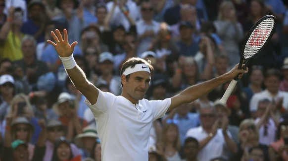 Roger Federer of Switzerland celebrates after winning his quarter final match against Milos Raonic of Canada, during the Wimbledon Championships at the All England Lawn Tennis Club, in London, Britain ...