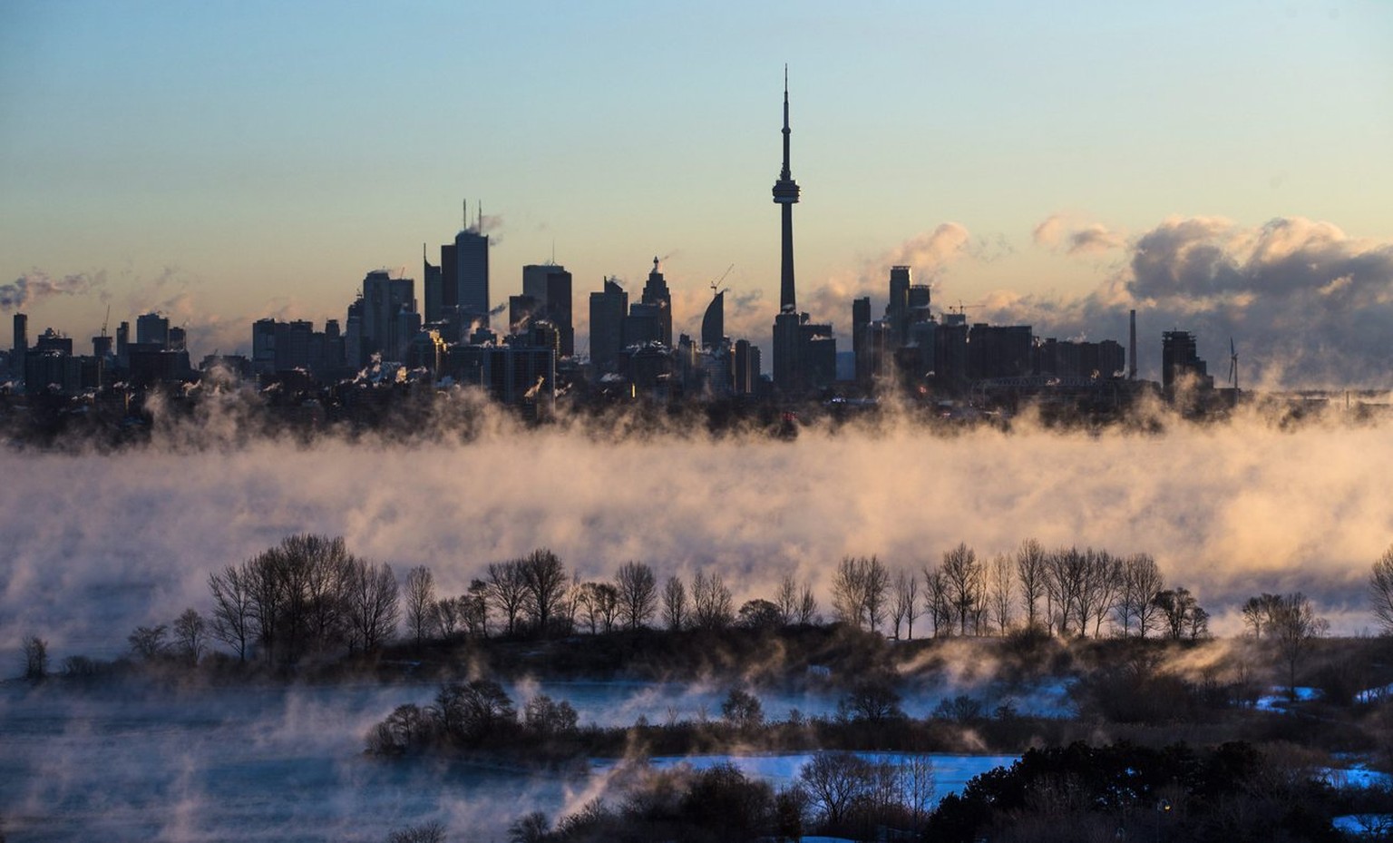 Mist rises from Lake Ontario in front of the Toronto skyline during extreme cold weather on Saturday, Feb. 13, 2016. Environment Canada has issued extreme cold warnings for provinces from Manitoba to  ...