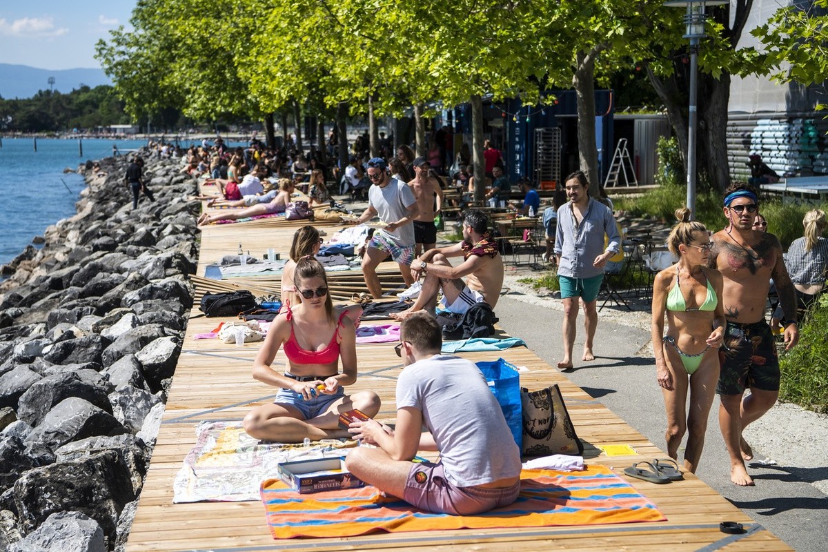 Des personnes profitent du soleil sur le deck de la "Jetee de la Compagnie" au bord du lac Leman lors de la crise du Coronavirus (Covid-19) le dimanche 17 mai 2020 a Lausanne. (KEYSTONE/Jean ...