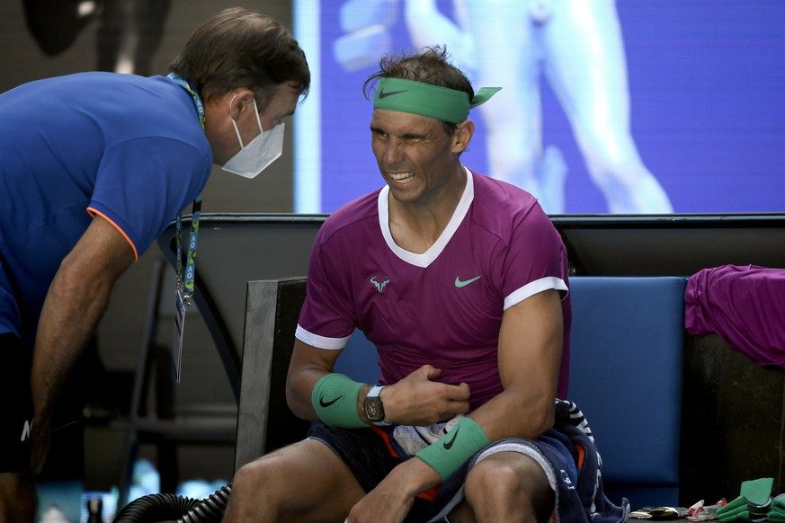 Rafael Nadal of Spain talks to medical staff during break in his quarterfinal match against Denis Shapovalov of Canada at the Australian Open tennis championships in Melbourne, Australia, Tuesday, Jan ...