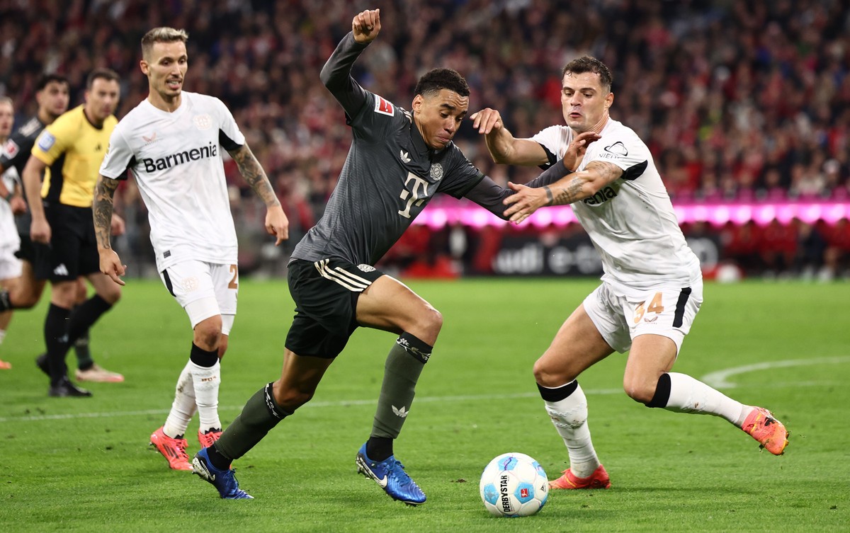 epa11630886 Jamal Musiala of Munich (L) in action against Granit Xhaka of Leverkusen (R) during the German Bundesliga soccer match between Bayern Munich and Bayer 04 Leverkusen in Munich, Germany, 28  ...
